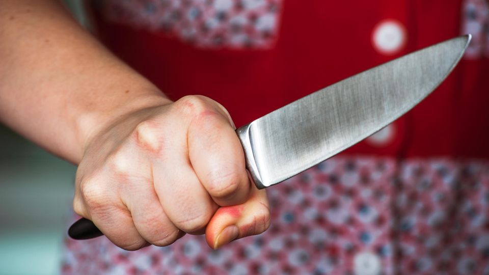 Eine Frau hält ein Messer in der Hand