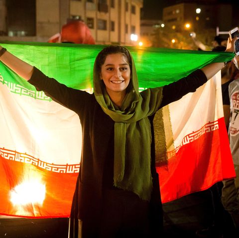 Ein iranische Frau feiert mit der Nationalflagge die Qualifikation des Herren-Fußballteams zur WM 2018 in Russland