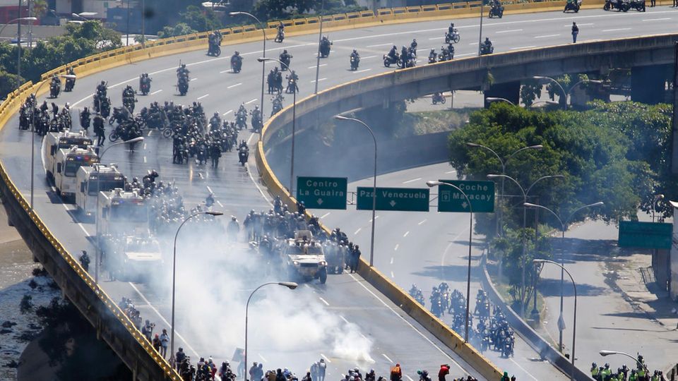 Volksaufstand in Venezuela: Auf einer Schnellstraße treffen hochgerüstete Polizeieinheiten und Demonstranten aufeinander Auf einer Schnellstraße treffen hochgerüstete Polizeieinheiten und Demonstranten aufeinander