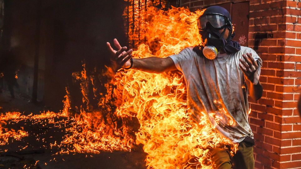 Volksaufstand in Venezuela: Ein Aktivist hat Feuer gefangen, nachdem der Tank eines Motorrads explodiert ist Ein Aktivist hat Feuer gefangen, nachdem der Tank eines Motorrads explodiert ist