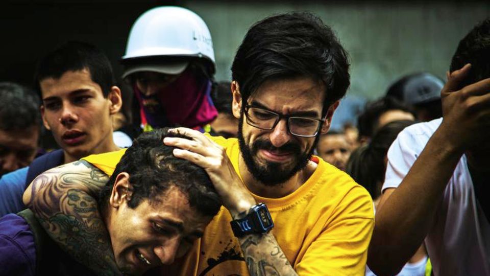 Volksaufstand in Venezuela: Miguel Pizarro tröstet Freunde, nachdem ein 17-Jähriger verblutet ist. Der Abgeordnete ist überzeugt, dass die Demonstranten trotz allem friedlich bleiben müssen Miguel Pizarro tröstet Freunde, nachdem ein 17-Jähriger verblutet ist. Der Abgeordnete ist überzeugt, dass die Demonstranten trotz allem friedlich bleiben müssen
