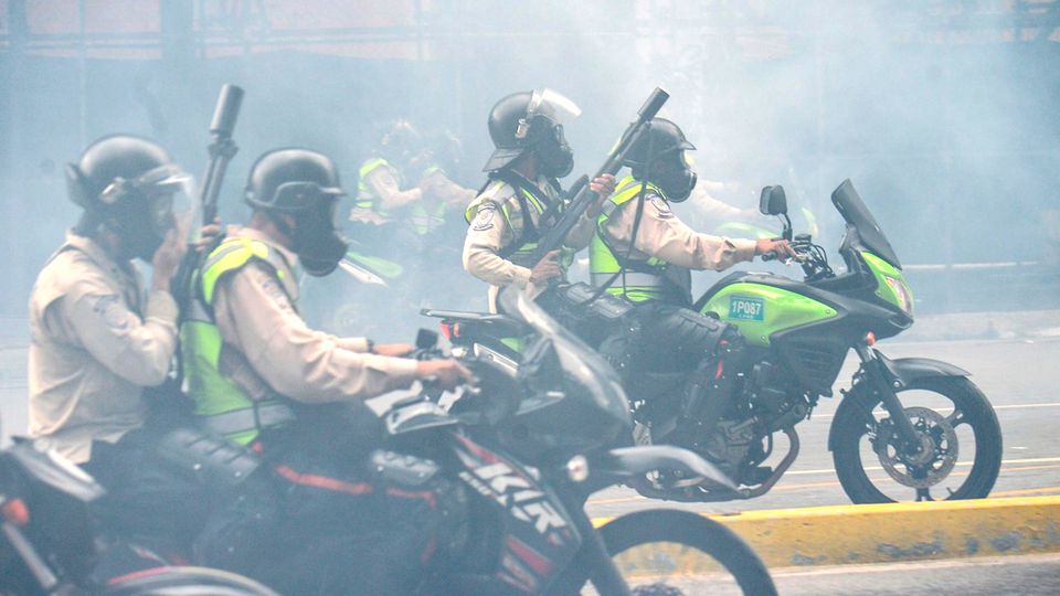 Volksaufstand in Venezuela: Polizeieinheiten auf Motorrädern gehen mit brutaler Gewalt gegen die Menschen vor. Die Luft ist geschwängert von Tränengas Polizeieinheiten auf Motorrädern gehen mit brutaler Gewalt gegen die Menschen vor. Die Luft ist geschwängert von Tränengas