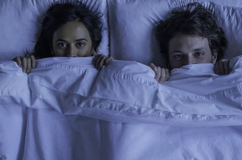 Zwei junge Menschen fürchten sich im Bett