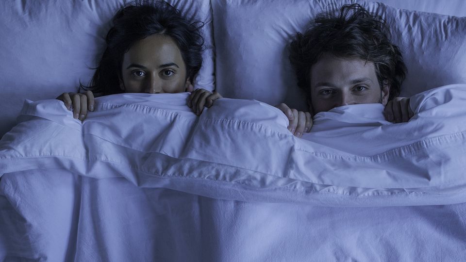 Zwei junge Menschen fürchten sich im Bett