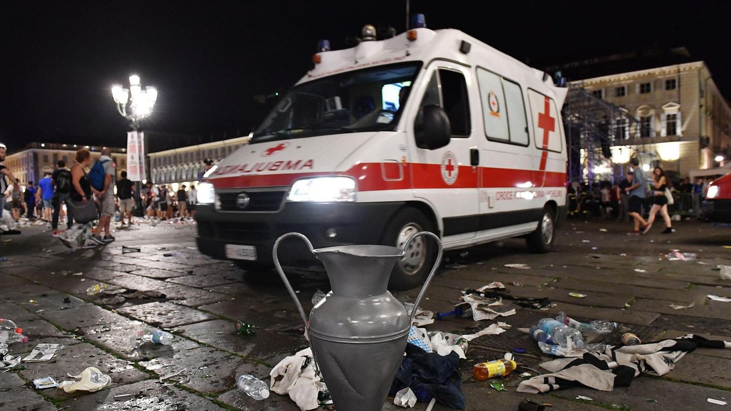 Ein Krankenwagen fährt in Turin nach der Massenpanik an einer Nachbildung des Champions-League-Pokals vorbei