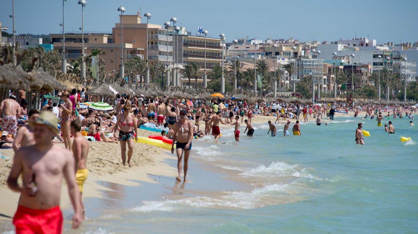 Touristen im Urlaub an einem Strand auf Mallorca