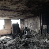 Der Boden ist übersät mit verkohlten Gegenständen, die Wände sind schwarz gefärbt