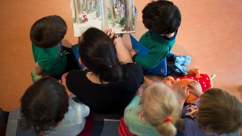 Eine Mutter liest Kindern ein Buch vor
