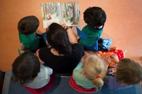 Eine Mutter liest Kindern ein Buch vor