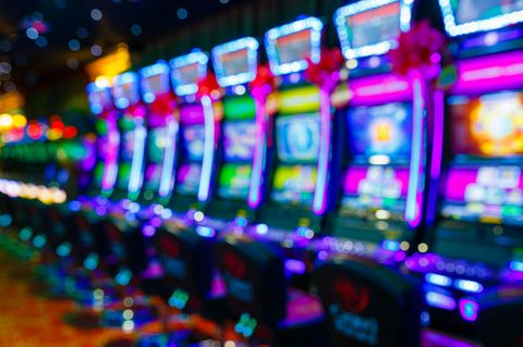 Eine Reihe von bunt beleuchteten Spielautomaten in einem Casino