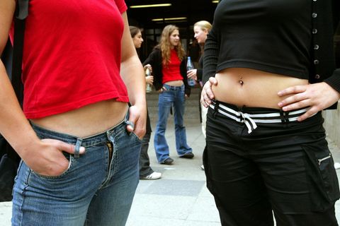 Zwei Frauen mit bauchfreien Tops vor einer Schule (Symbolbild)