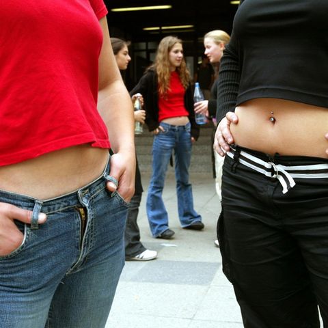 Zwei Frauen mit bauchfreien Tops vor einer Schule (Symbolbild)