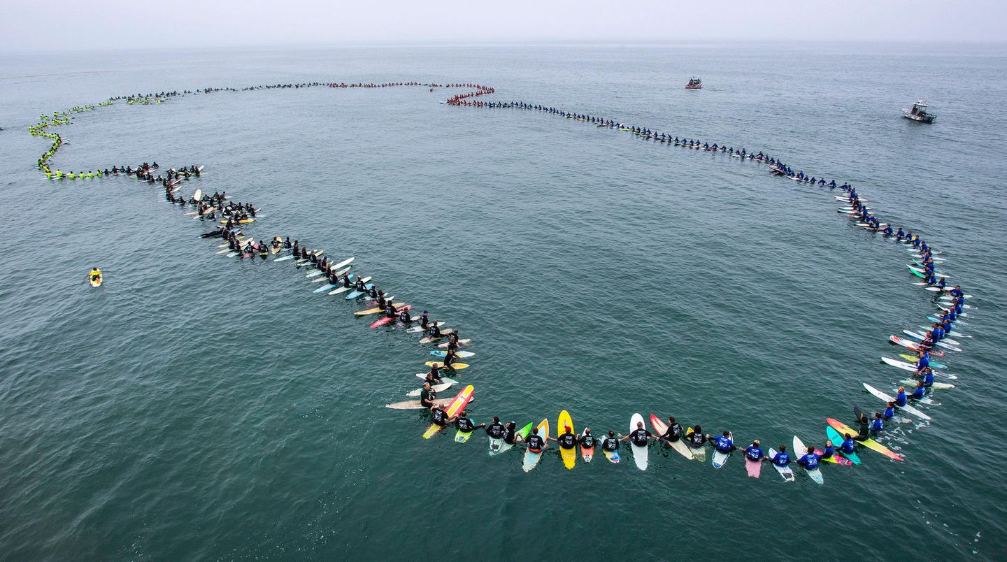 Bilder des Jahres: Juni Huntington Beach, USA: Surfer formen einen Kreis auf dem Ozean und halten sich dabei an den Händen. Das Ritual wird "Paddle Out" genannt und gilt normalerweise dem Gedenken verstorbener Surfer. 511 Surfer nahmen an dem "Paddle Out" teil, sie stellten einen neuen Weltrekord für die meisten Teilnehmer an dem Ritual auf. Juni Huntington Beach, USA: Surfer formen einen Kreis auf dem Ozean und halten sich dabei an den Händen. Das Ritual wird "Paddle Out" genannt und gilt normalerweise dem Gedenken verstorbener Surfer. 511 Surfer nahmen an dem "Paddle Out" teil, sie stellten einen neuen Weltrekord für die meisten Teilnehmer an dem Ritual auf.
