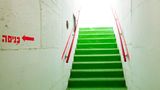 Eine grüne Treppe führt bei diesem Gebäude in Haifa in die schützenden Räumlichkeiten des Bunkers