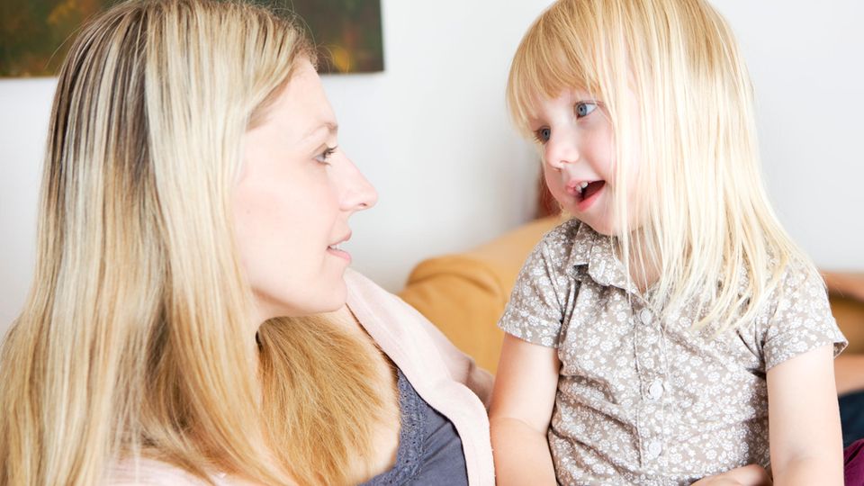 Mutter mit Tochter Mutter und junge Tochter sitzen gemeinsam auf dem Sofa