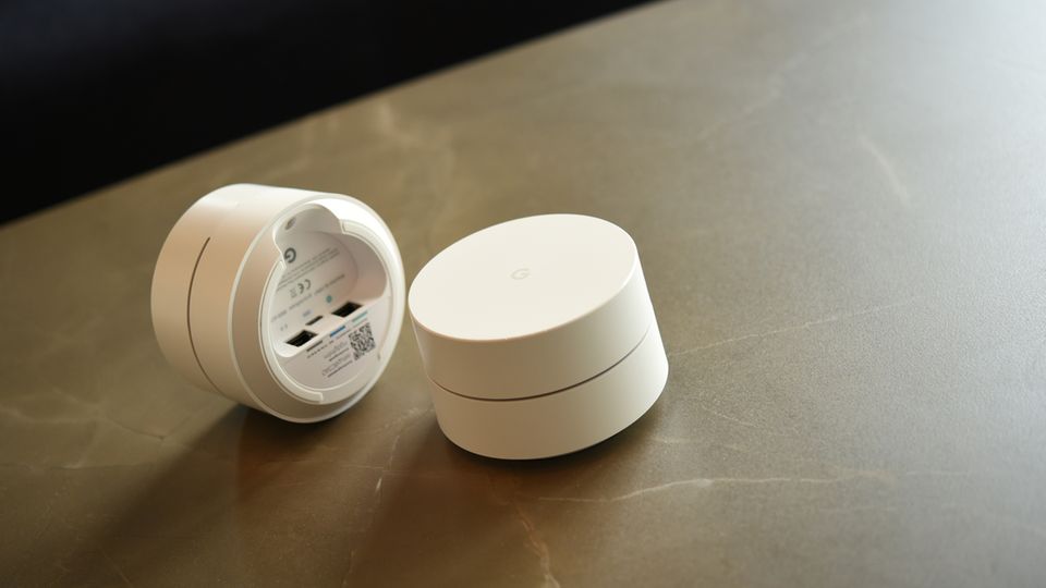 Google Wifi im Test Zwei Google Wifi liegen nebeneinander auf einer Steinplatte