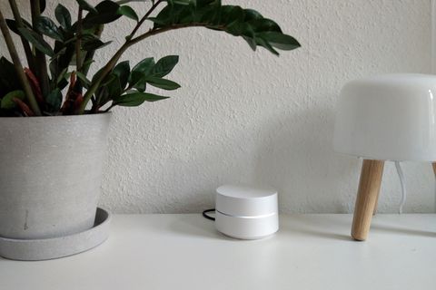 Google Wifi stebht auf einer weißen Fernsehbank