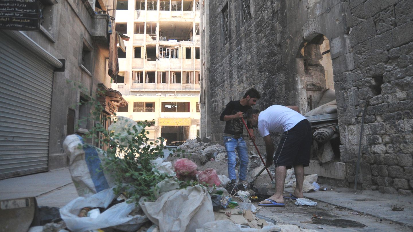 Anwohner räumen im Westen Aleppos Trümmer und Schutt von der Straße