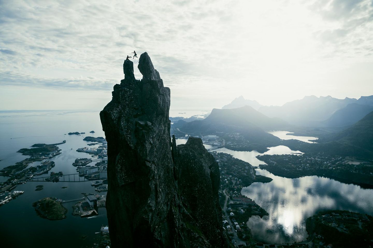 Norwegen: Beinahe im Himmel Gipfelsprung eines Kletterers über Svolvær auf den Lofoten-Inseln