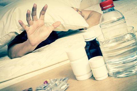 Ein Mann greift zu Kopfschmerztabletten