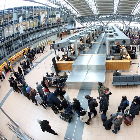 Lange Schllangen: Flugpassagiere warten am Flughafen in Hamburg auf die Abfertigung an den Check-In-Schaltern.