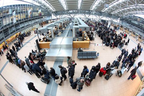 Lange Schllangen: Flugpassagiere warten am Flughafen in Hamburg auf die Abfertigung an den Check-In-Schaltern.