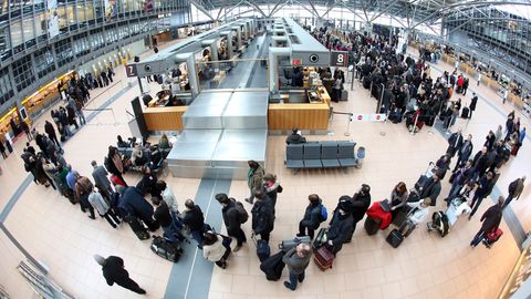 Lange Schllangen: Flugpassagiere warten am Flughafen in Hamburg auf die Abfertigung an den Check-In-Schaltern.