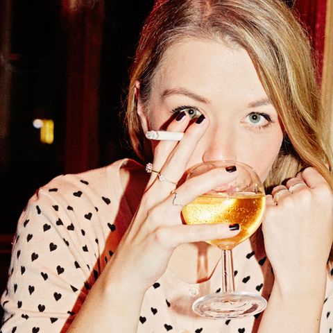 Julia Schramm mit Zigarette und einem Glas Weißwein