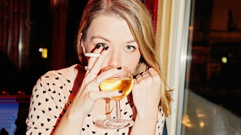 Julia Schramm mit Zigarette und einem Glas Weißwein