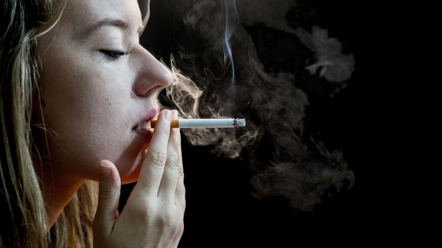 Женщины курят на фоне завода