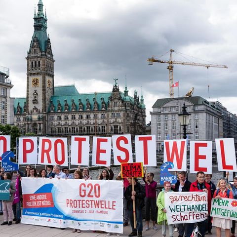 Aktivisten der geplanten Protestaktion „G20-Protestwelle“ werben vor dem Hamburger Rathaus für die Akltion