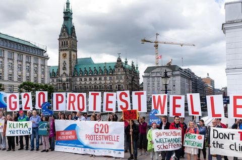 Aktivisten der geplanten Protestaktion „G20-Protestwelle“ werben vor dem Hamburger Rathaus für die Akltion