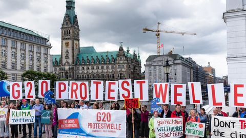 Aktivisten der geplanten Protestaktion „G20-Protestwelle“ werben vor dem Hamburger Rathaus für die Akltion
