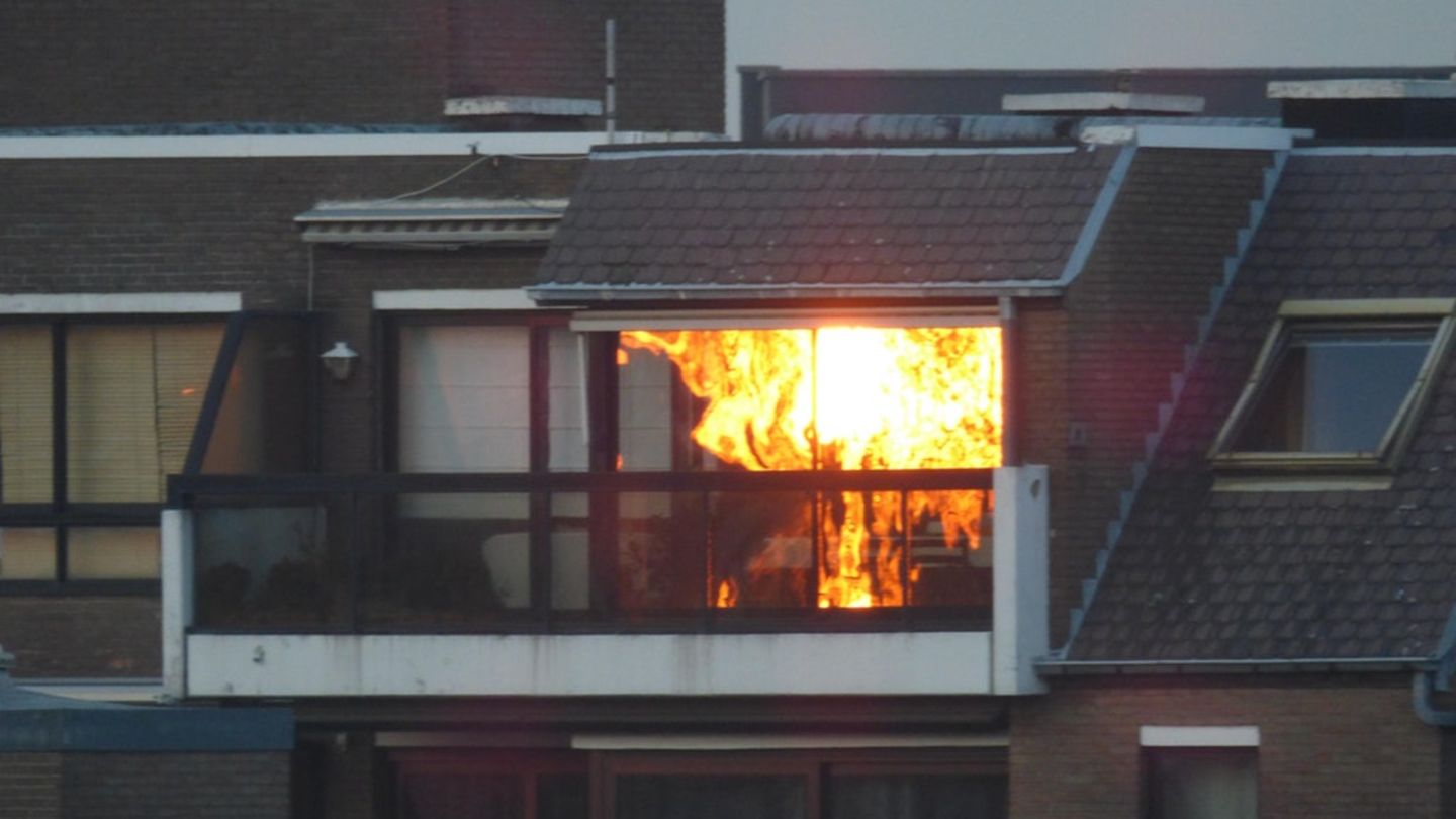 Fotografie eines Hauses, in dem es scheinbar brennt - in Wirklichkeit spiegelt sich im Fenster ein Sonnenuntergang