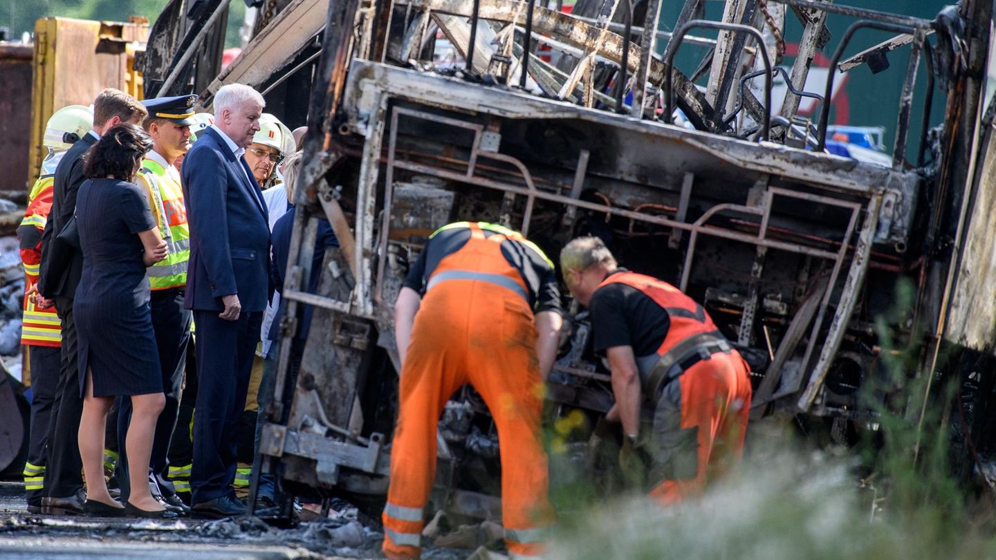 Busunglück in Bayern: Ministerpräsident Horst Seehofer steht zusammen mit Einsatzkräften an dem verunfallten Reisebus.