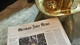 Auf dem Couchtisch liegt "German Fake News" als lokaler Medienservice für Donald Trump bereit