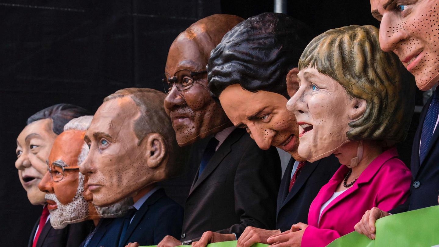 Auf einer Demo vor dem G20-Gipfel tragen Schausteller Masken der Staatschef der Teilnehmernationen