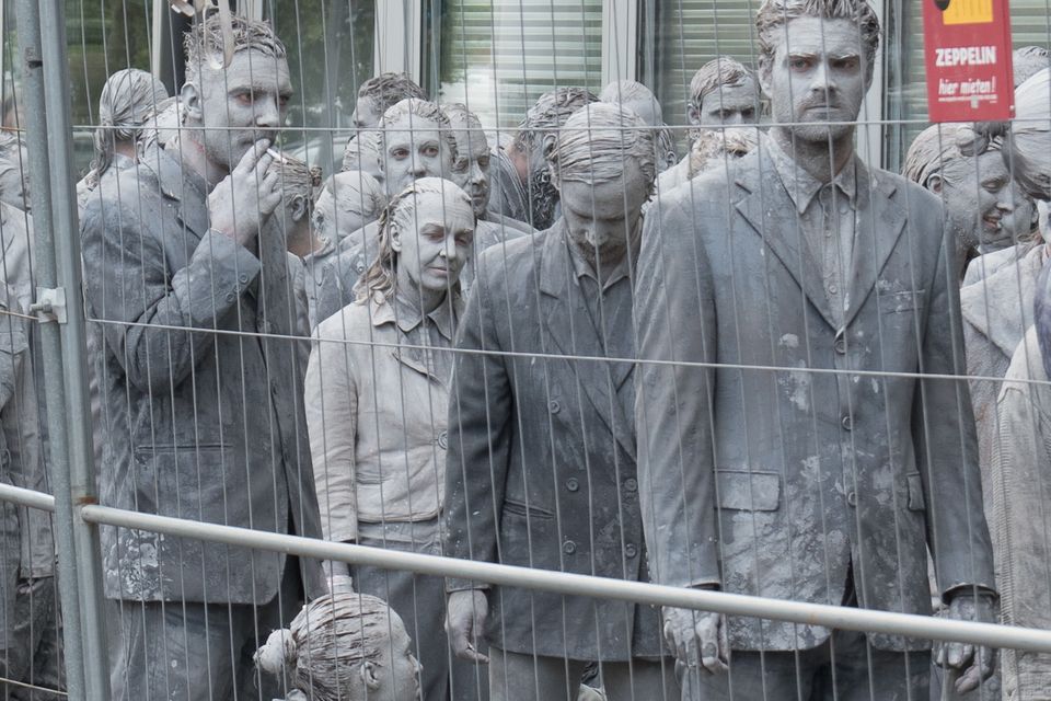 1000 Gestalten Graue Gestalten hinter einem Zaun