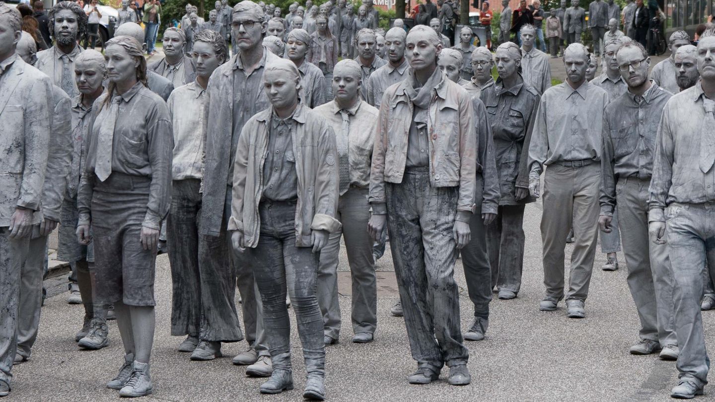 Grau gekleidete Akteure marschieren gegen G20