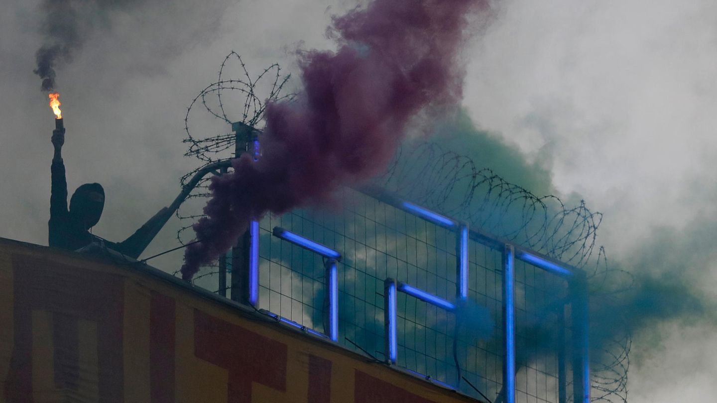 Ein Demonstrant steht zum Abschluss eines Rave-Protestzugs durch die Straßen Hamburgs am Mittwochabend mit einem Bengalo auf dem Dach der Roten Flora, dem Autonomen Zentrum im Schanzenviertel.