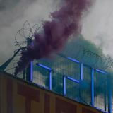 Ein Demonstrant steht zum Abschluss eines Rave-Protestzugs durch die Straßen Hamburgs am Mittwochabend mit einem Bengalo auf dem Dach der Roten Flora, dem Autonomen Zentrum im Schanzenviertel.