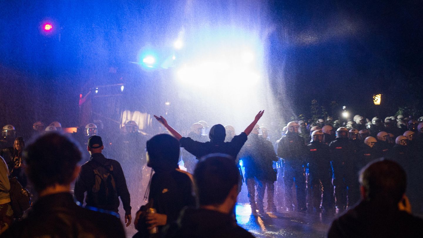 Politik und Protest: Ein Wasserwerfer der Polizei spritzt am Neuen Pferdemarkt im Stadtteil St. Pauli Wasser auf eine Menschenmenge. Hunderte Menschen hielten sich hier am Dienstagabend auf der Straße auf und behinderten den Verkehr, ehe die Polizei begann, den Neuen Pferdemarkt zu räumen. Ein Wasserwerfer der Polizei spritzt am Neuen Pferdemarkt im Stadtteil St. Pauli Wasser auf eine Menschenmenge. Hunderte Menschen hielten sich hier am Dienstagabend auf der Straße auf und behinderten den Verkehr, ehe die Polizei begann, den Neuen Pferdemarkt zu räumen.