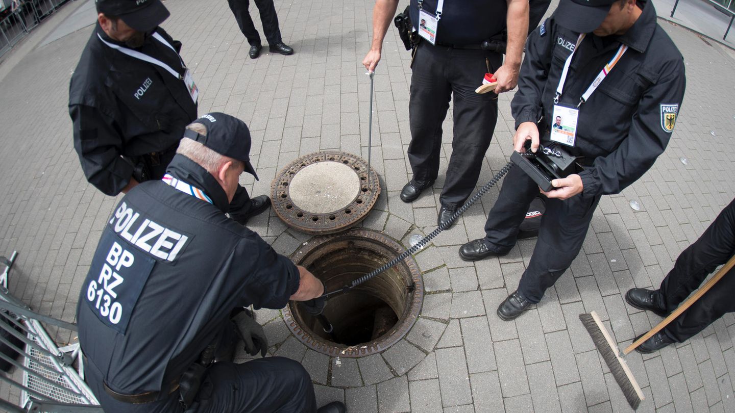 Mit Spiegeln, Sonden und Kameras untersuchen technische Einsatzkräfte der Bundespolizei einen Gully im Eingangsbereich für die Delegierten an den Messehallen