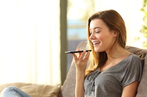 Eine Frau spricht in das Mikro ihres Smartphones