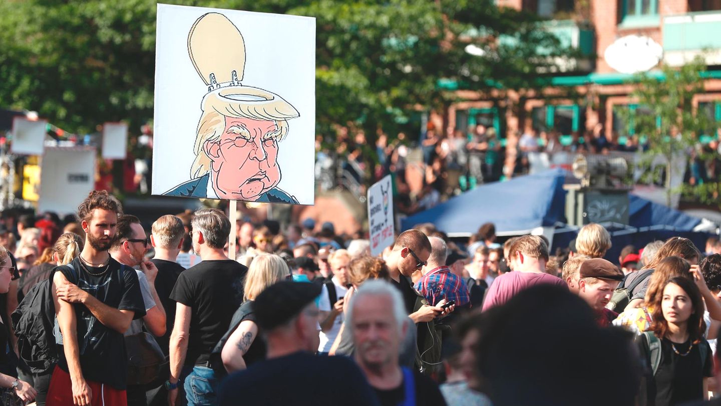 Die Menschenmenge am Fischmarkt wächst am Donnerstagnachmittag immer weiter an. Was die Demonstranten von Donald Trump halten, zeigt dieses Plakat.