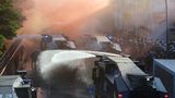 Die Lage eskaliert: Die Polizei stoppt den Demonstrationszug, weil die Mitglieder des Schwarzen Blocks sich weigern, ihre verbotenen Vermummungen abzulegen. Schließlich fliegen Flaschen und Steine, die Polizei setzt Wasserwerfer ein und die Demonstration wird aufgelöst.
