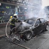 Ein Feuerwehrmann löscht ein brennendes Fahrzeug im Schanzenviertel