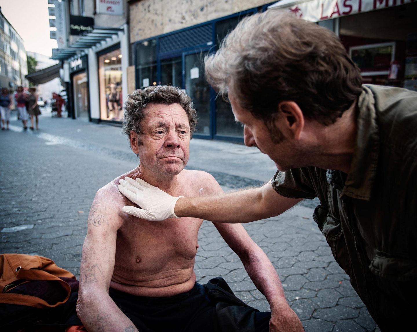 Die Fußgängerzone wird zur Arztpraxis: Trabert behandelt Herrn Dusas Haut