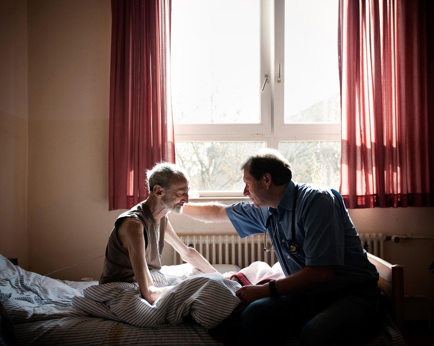 Gespräch auf Augenhöhe: Trabert bespricht mit einem Patienten die Verlegung in ein Hospiz