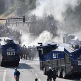 Kein Durchkommen: Polizisten halten eine Gruppe Demonstranten am Hafen auf